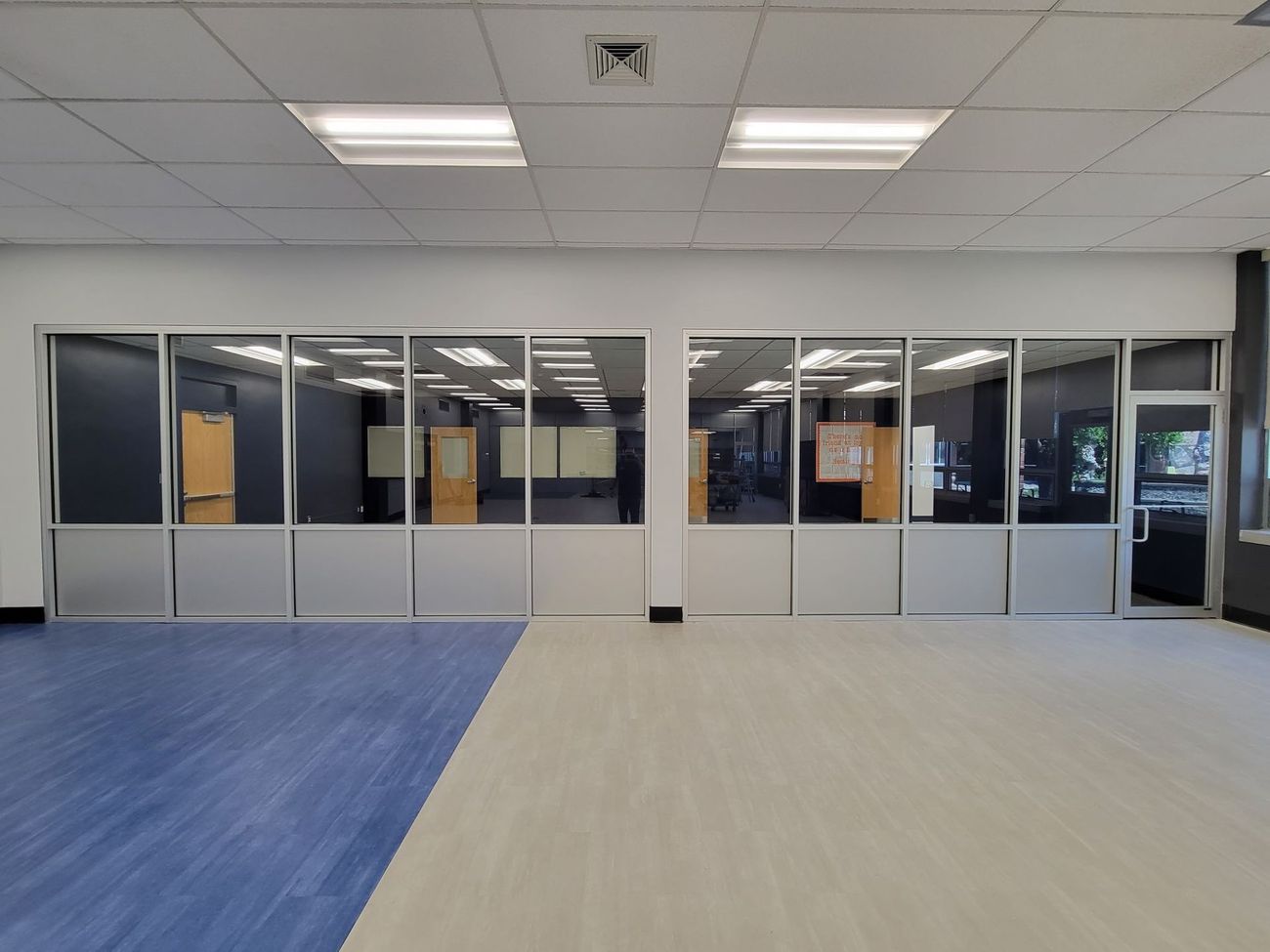 An empty room with a blue floor and a lot of windows