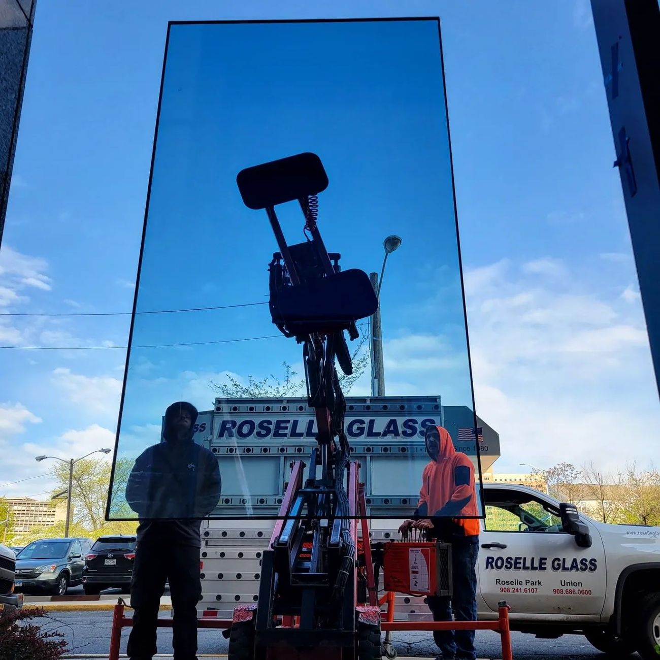 A man is standing in front of a truck that says roselle glass