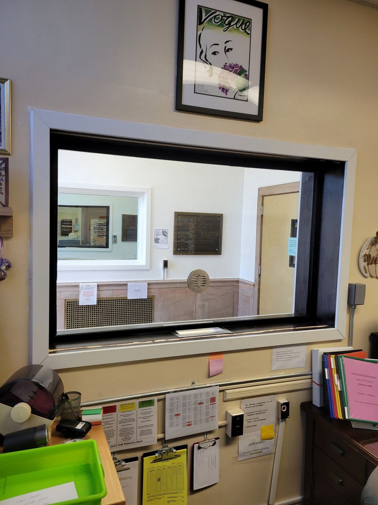 A large window with a picture on the wall above it