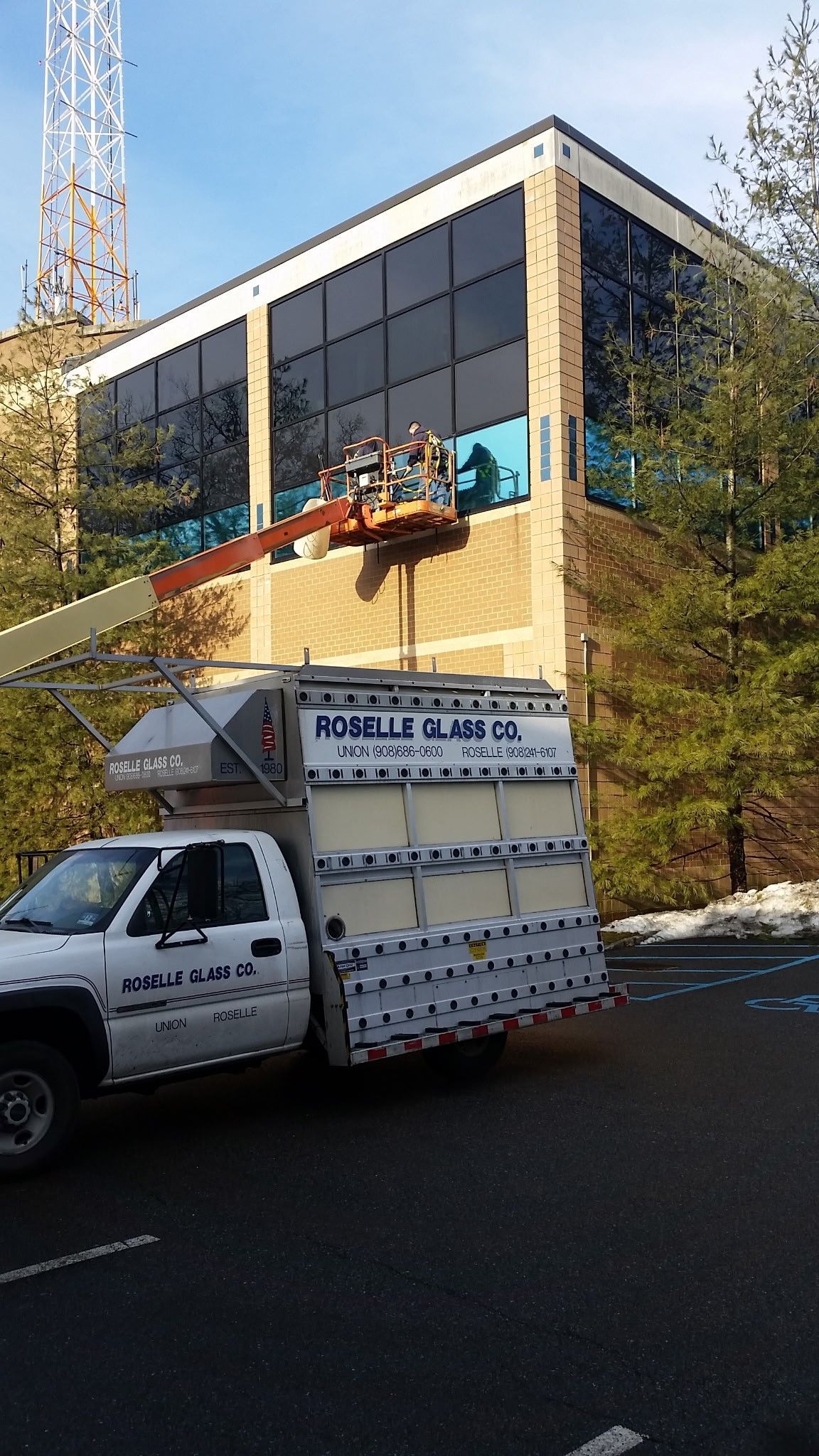 A white truck is parked in front of a large building.