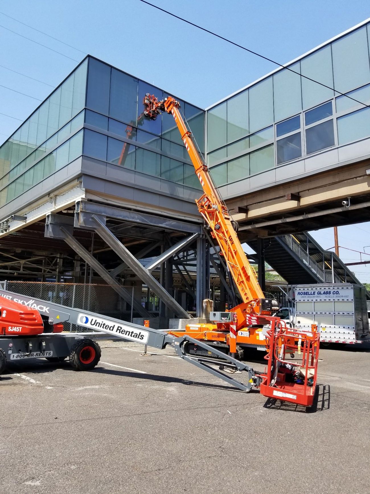 A crane is sitting in front of a building under construction.
