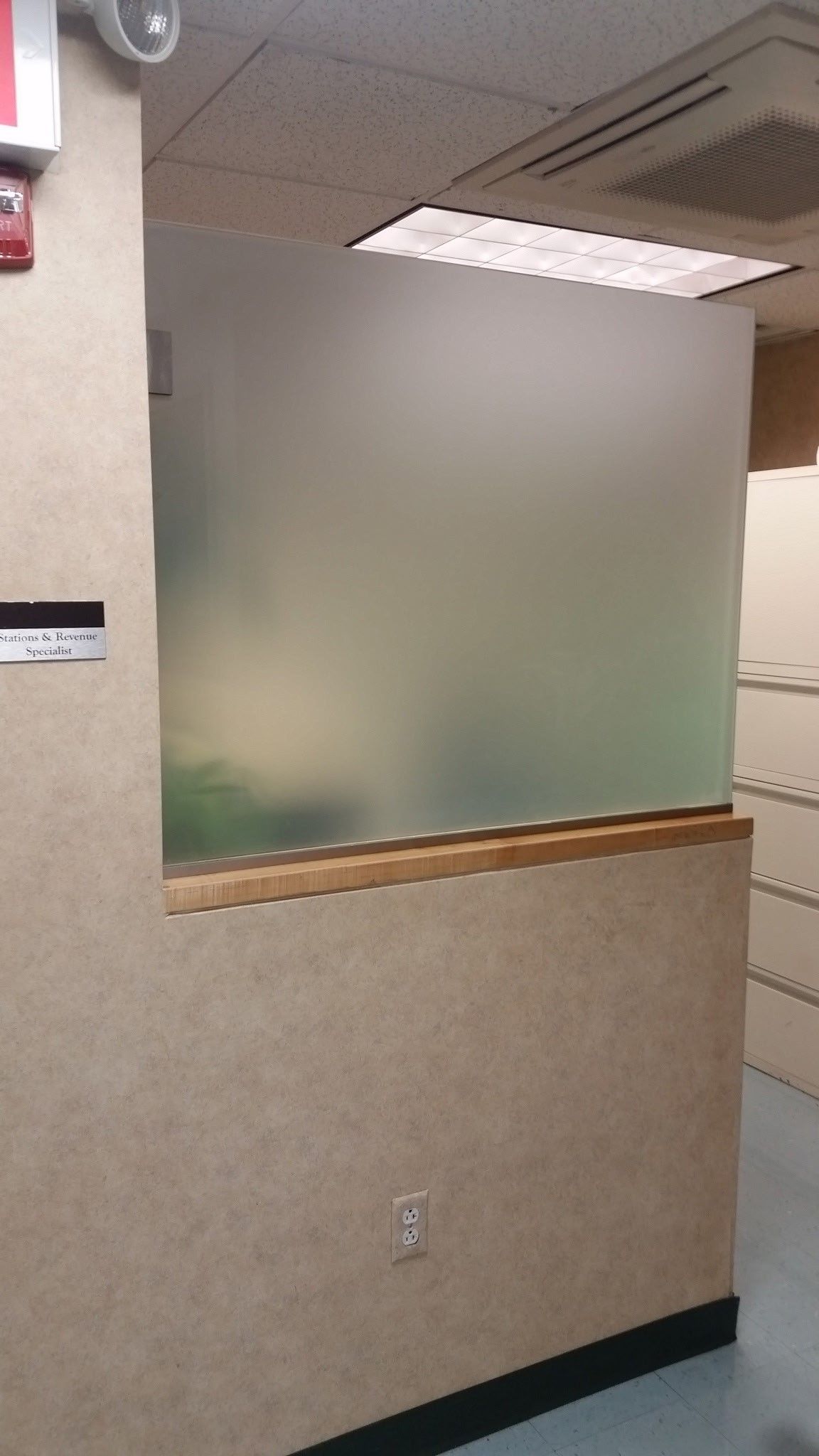 A room with a window and a frosted glass wall.