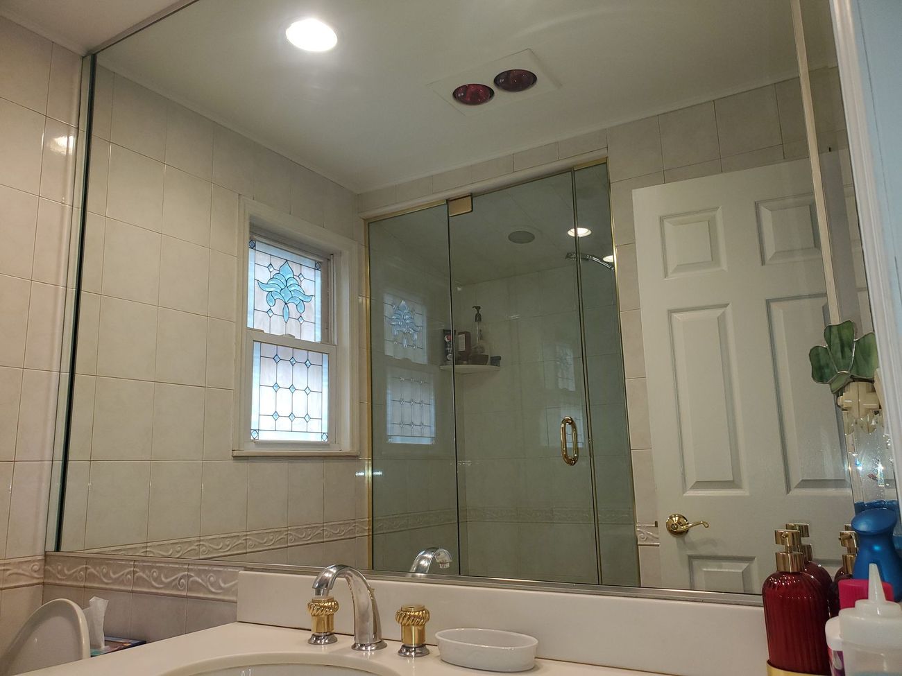 A bathroom with a sink and a large mirror