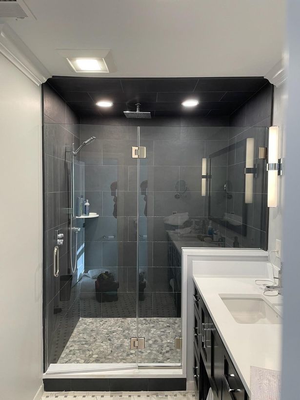 A bathroom with a walk in shower and a sink.