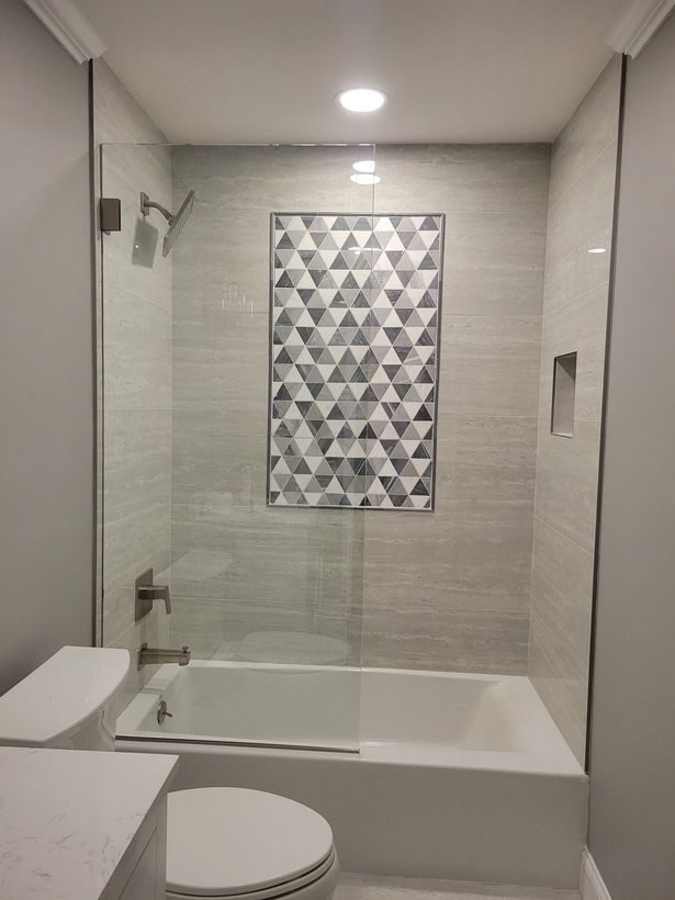 A bathroom with a tub , toilet , and shower.