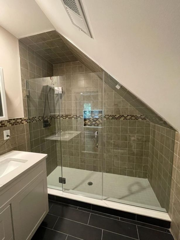 A bathroom with a walk in shower and a sink.