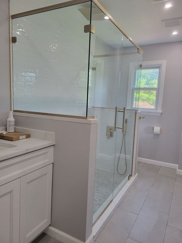 A bathroom with a walk in shower and a sink.