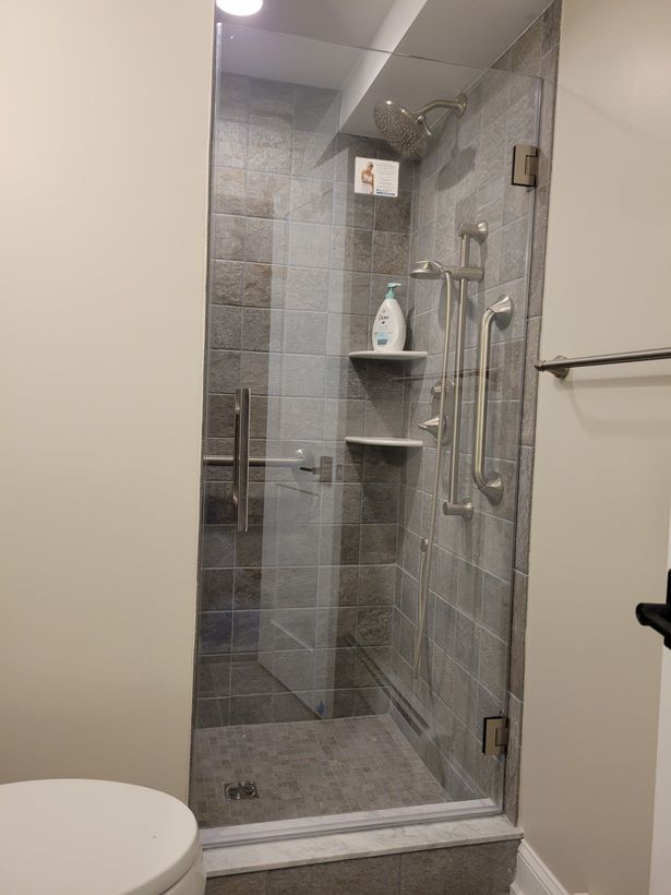 A bathroom with a walk in shower and a toilet.