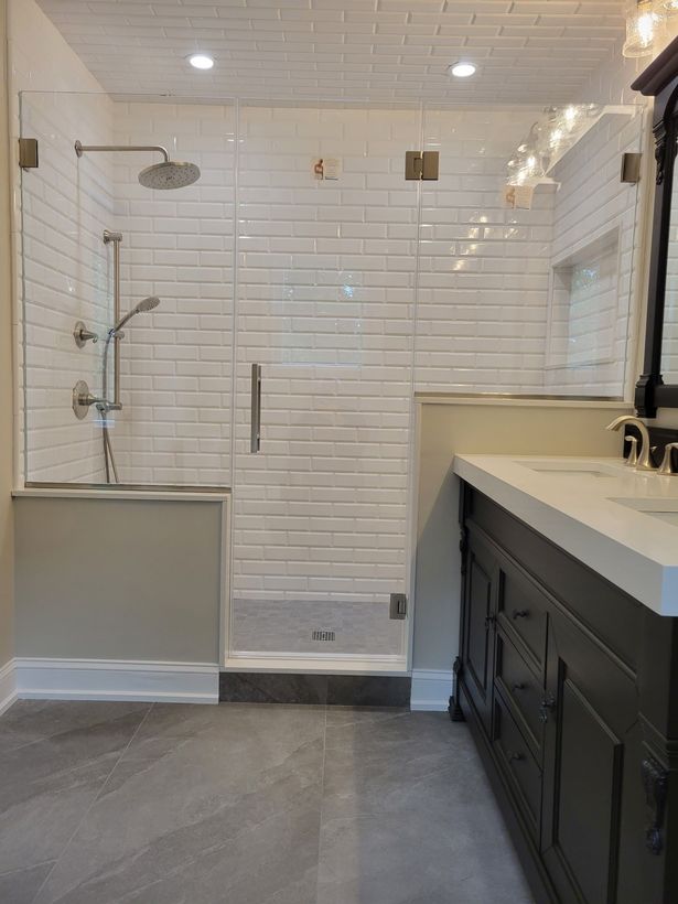 A bathroom with a walk in shower and a sink