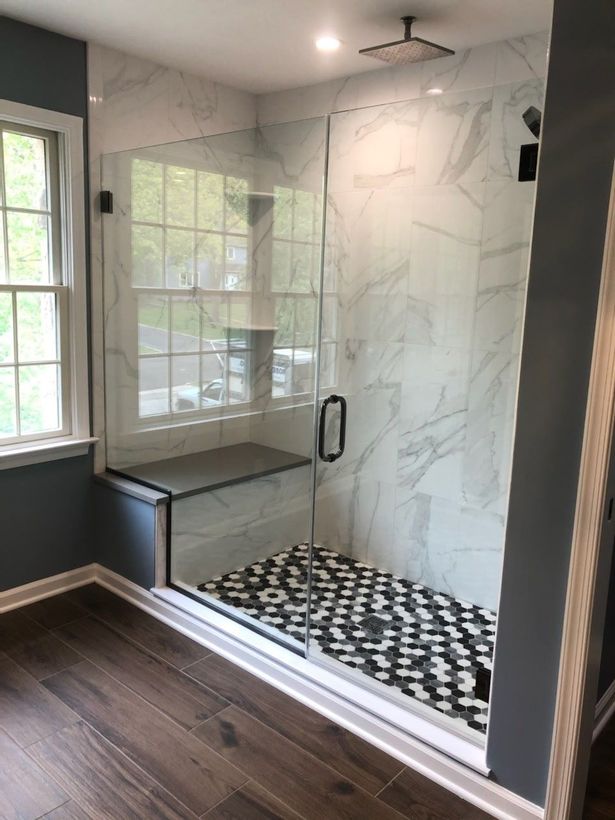 A bathroom with a walk in shower and a window