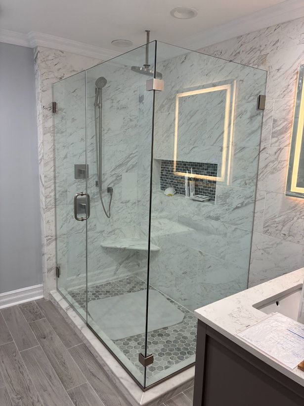 A bathroom with a walk in shower and a sink.