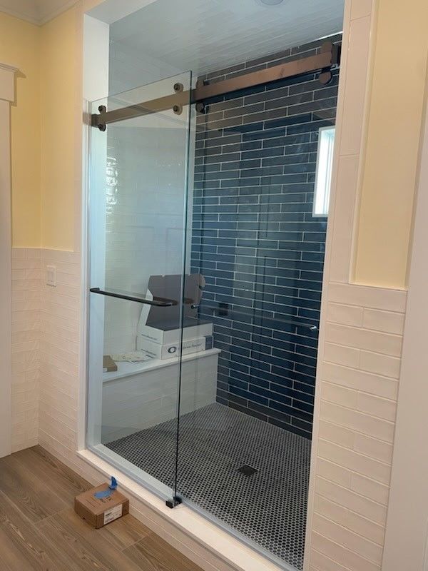 A bathroom with a sliding glass shower door and a bathtub.