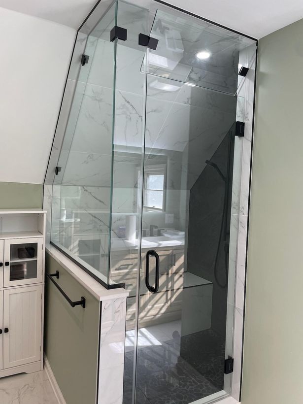 A bathroom with a glass shower door and a sink.
