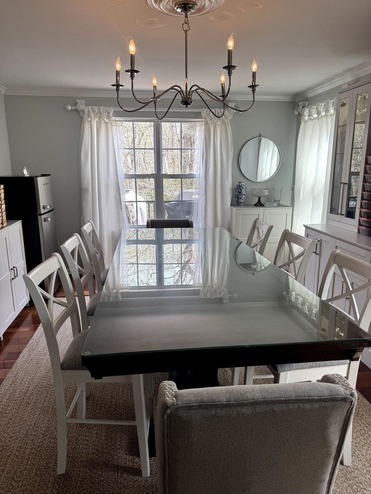 A dining room with a table and chairs and a chandelier.