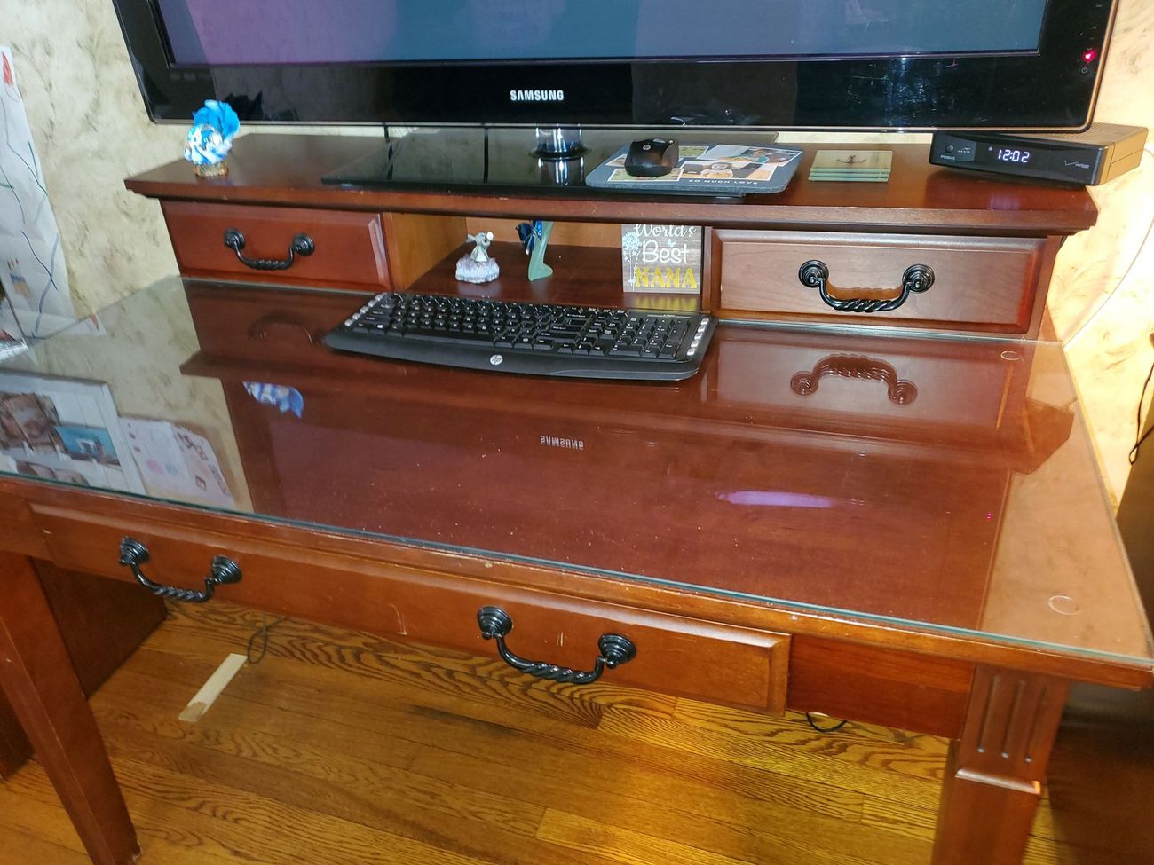 A desk with a keyboard and a tv on top of it