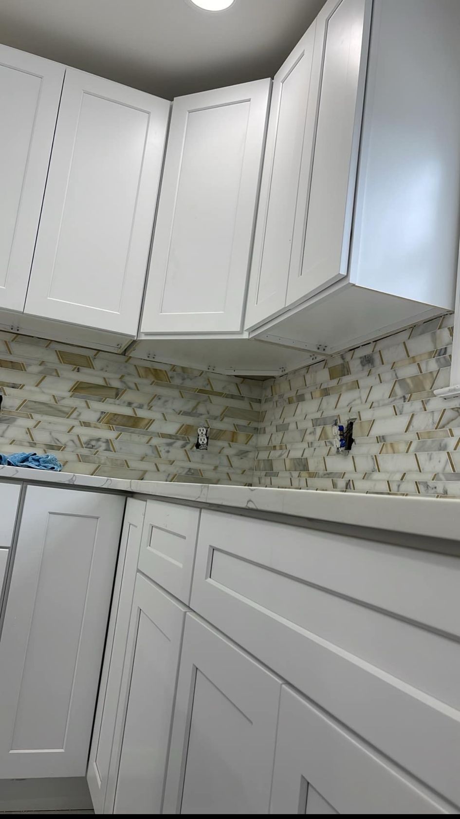 White kitchen cabinets with a stone tile backsplash.