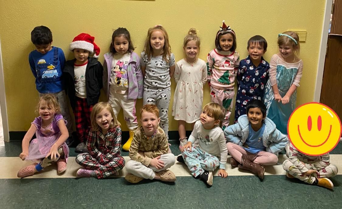 a group of children are posing for a picture in a hallway .