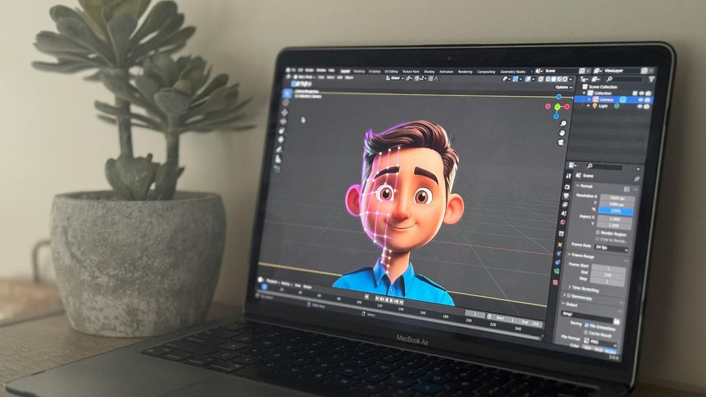 Laptop screen showing a 3D animated character in a modeling software. A plant sits beside the laptop.