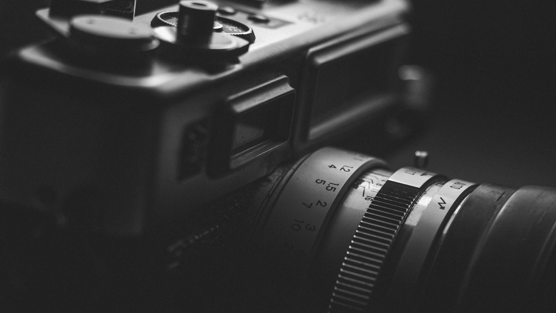 Black and white close-up of a vintage film camera lens.