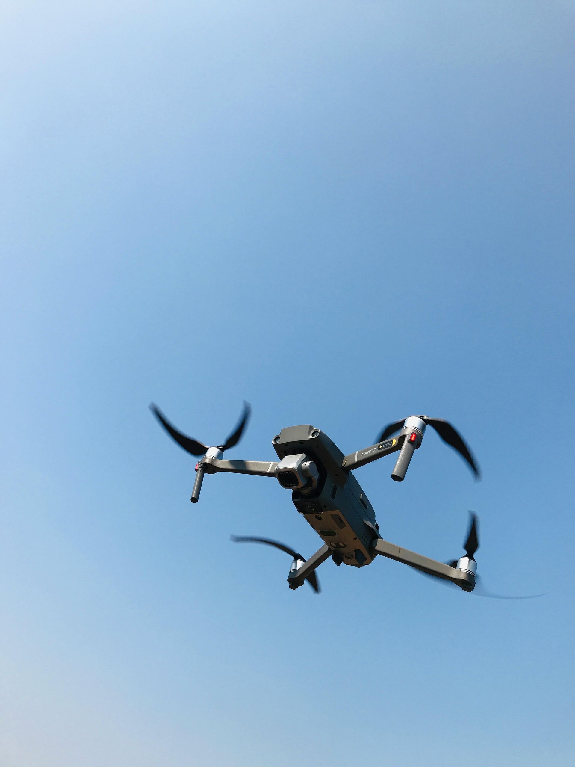 Drone flying in a blue sky.