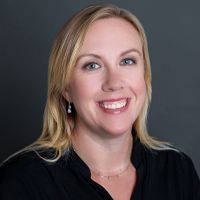 A woman in a black shirt is smiling for the camera.