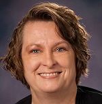 A woman with short brown hair is smiling for the camera.