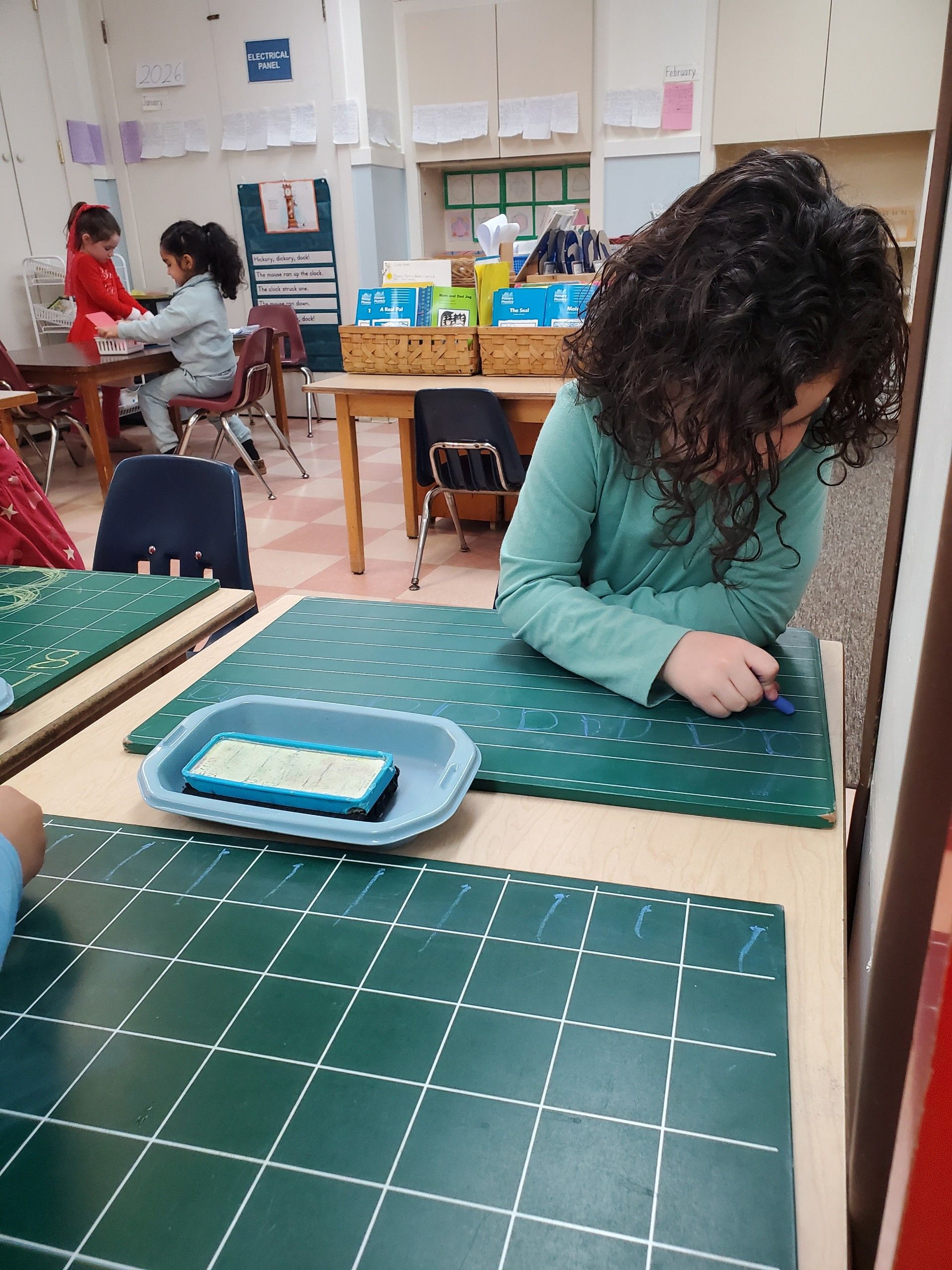 Child working on a chalkboard in a Montessori classroom.