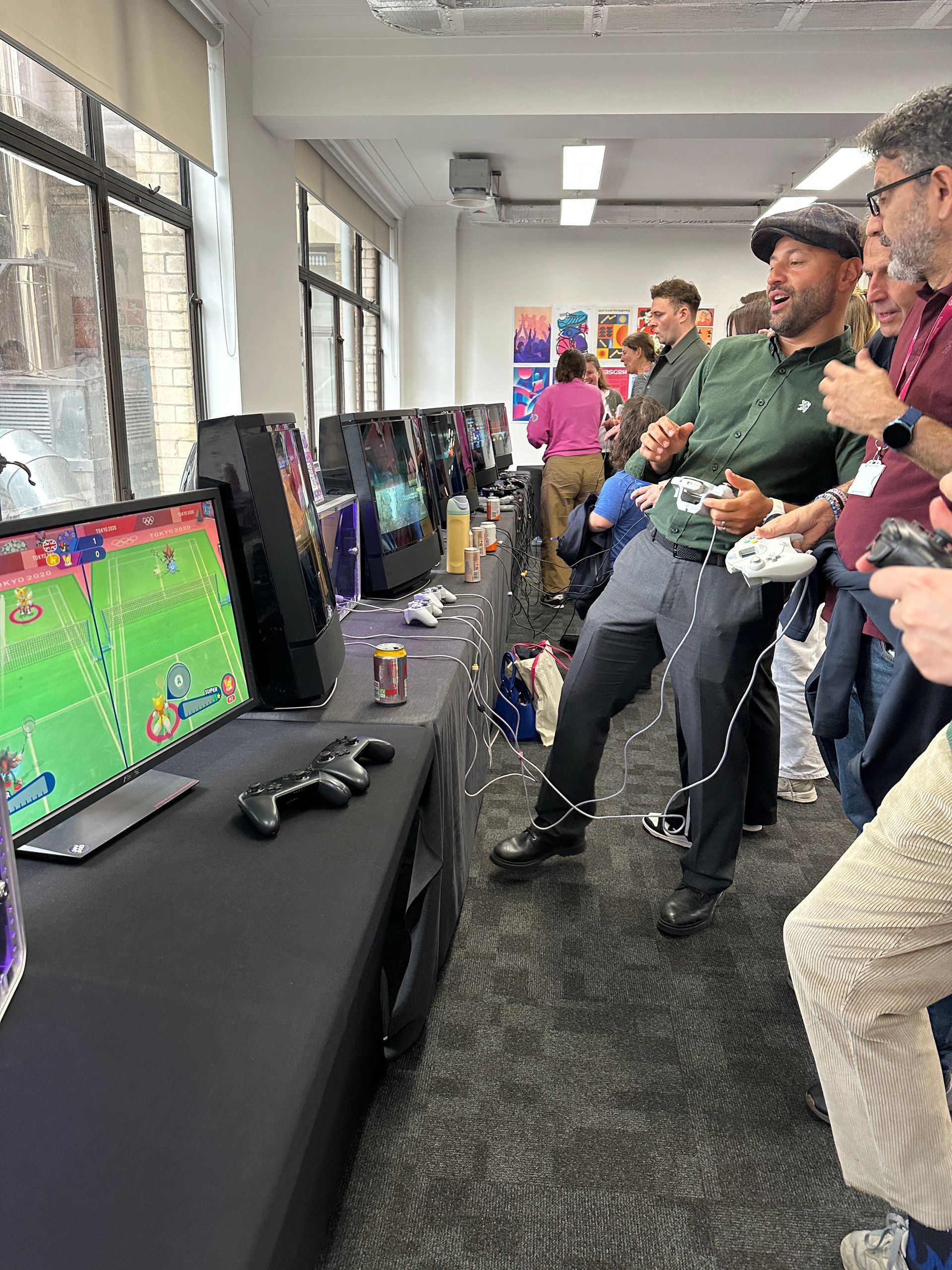 Joypad video game hire for workplace team building, a group of colleagues enjoying retro and modern video games in the office