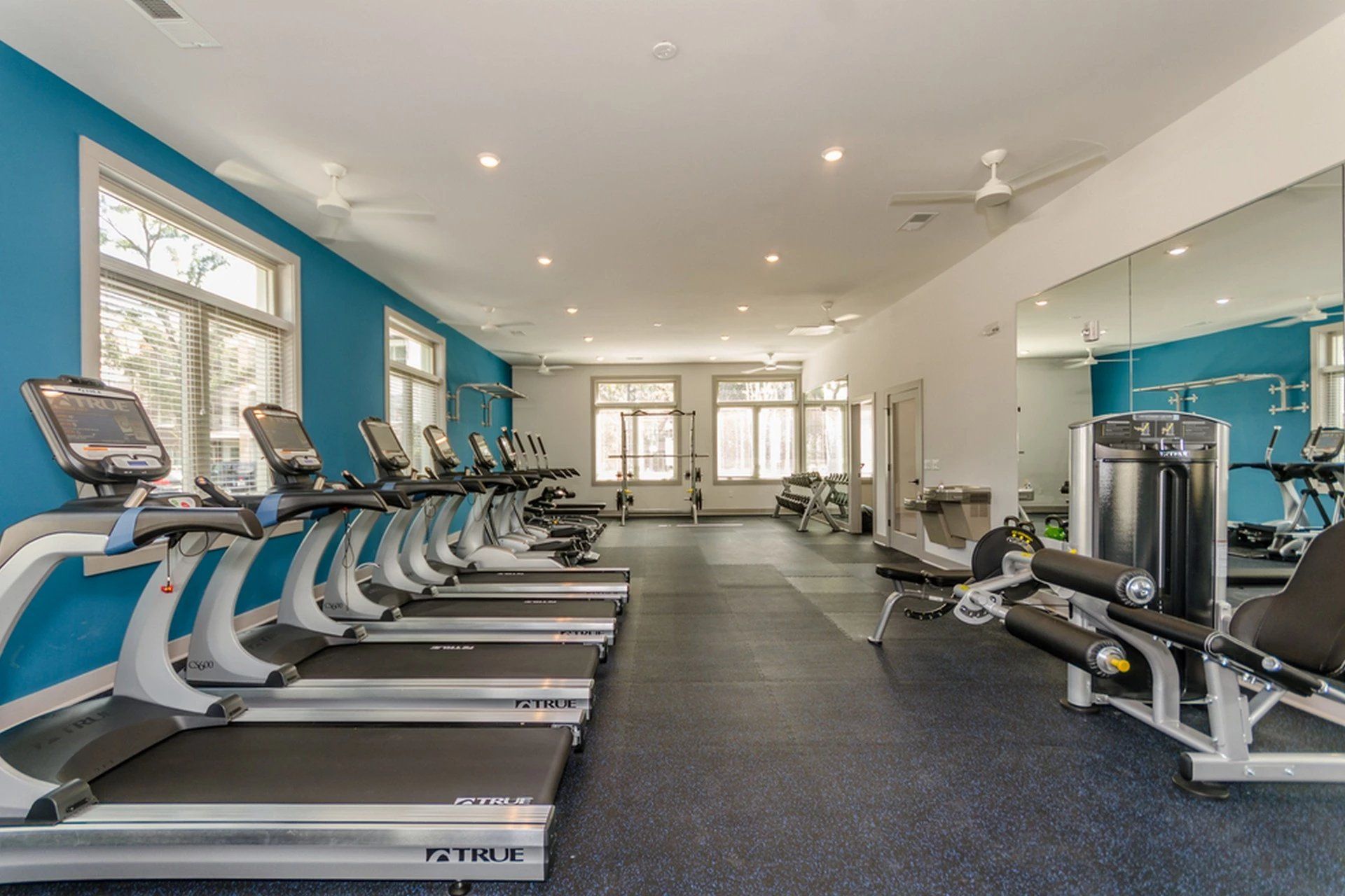 A large gym with a lot of treadmills and exercise equipment at Toledo Club Apartment, which offers apartments in North Port, FL.