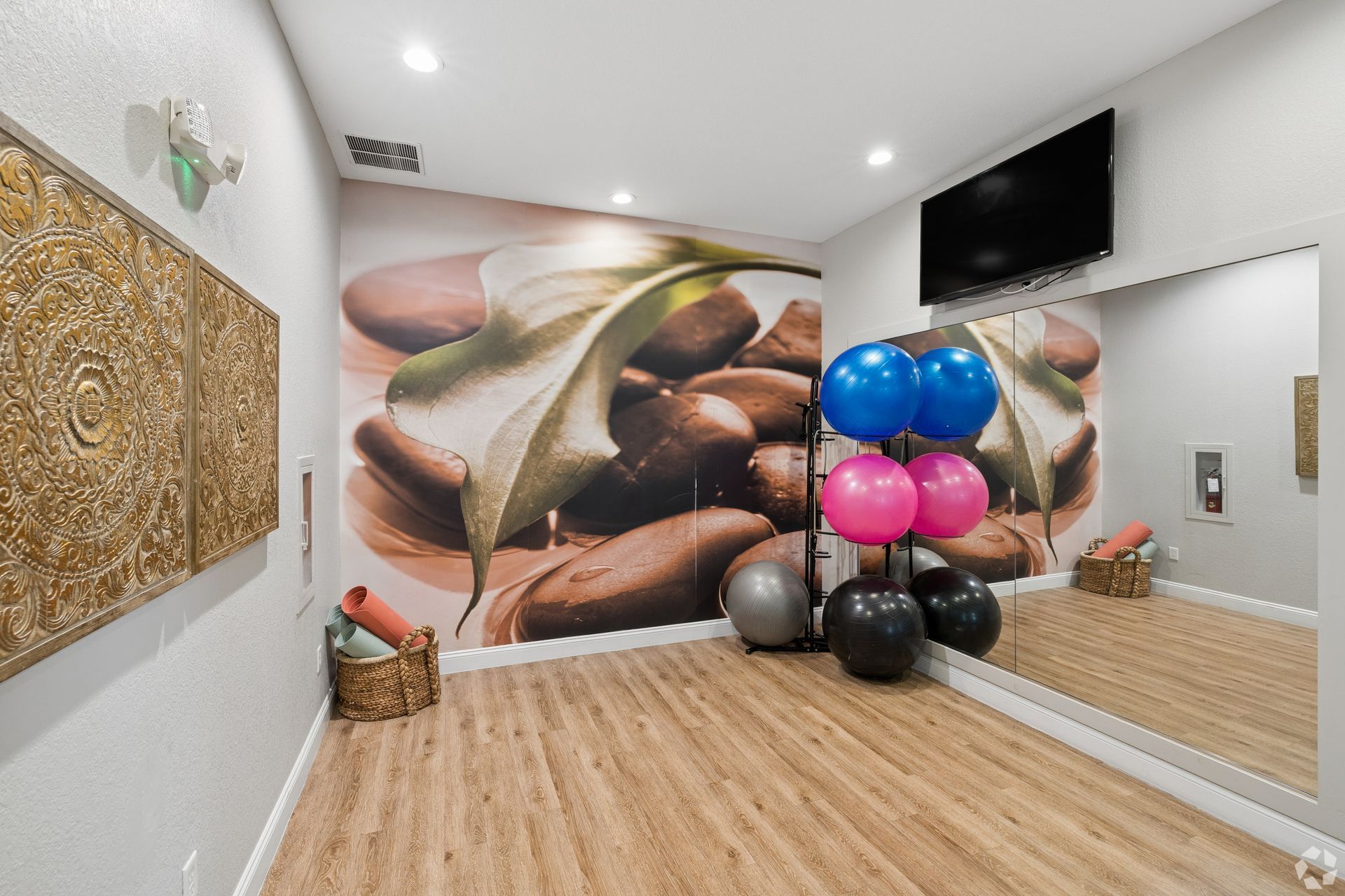 Spa room with massage wall mural, gold decor, mirrored wall, and blue, pink, and black balloons