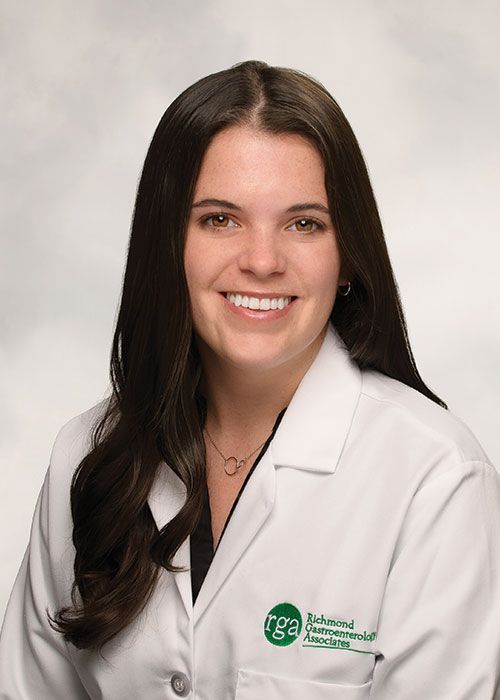 Portrait of a smiling doctor in a white coat and tie against a light gray background