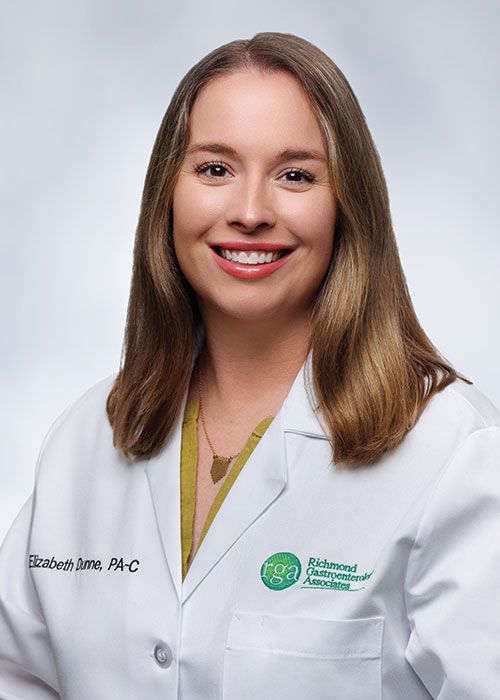 Portrait of a smiling doctor in a white coat and tie against a light gray background