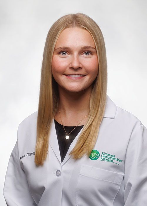 Portrait of a smiling doctor in a white coat and tie against a light gray background
