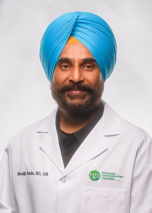 Portrait of a smiling doctor in a white coat and tie against a light gray background