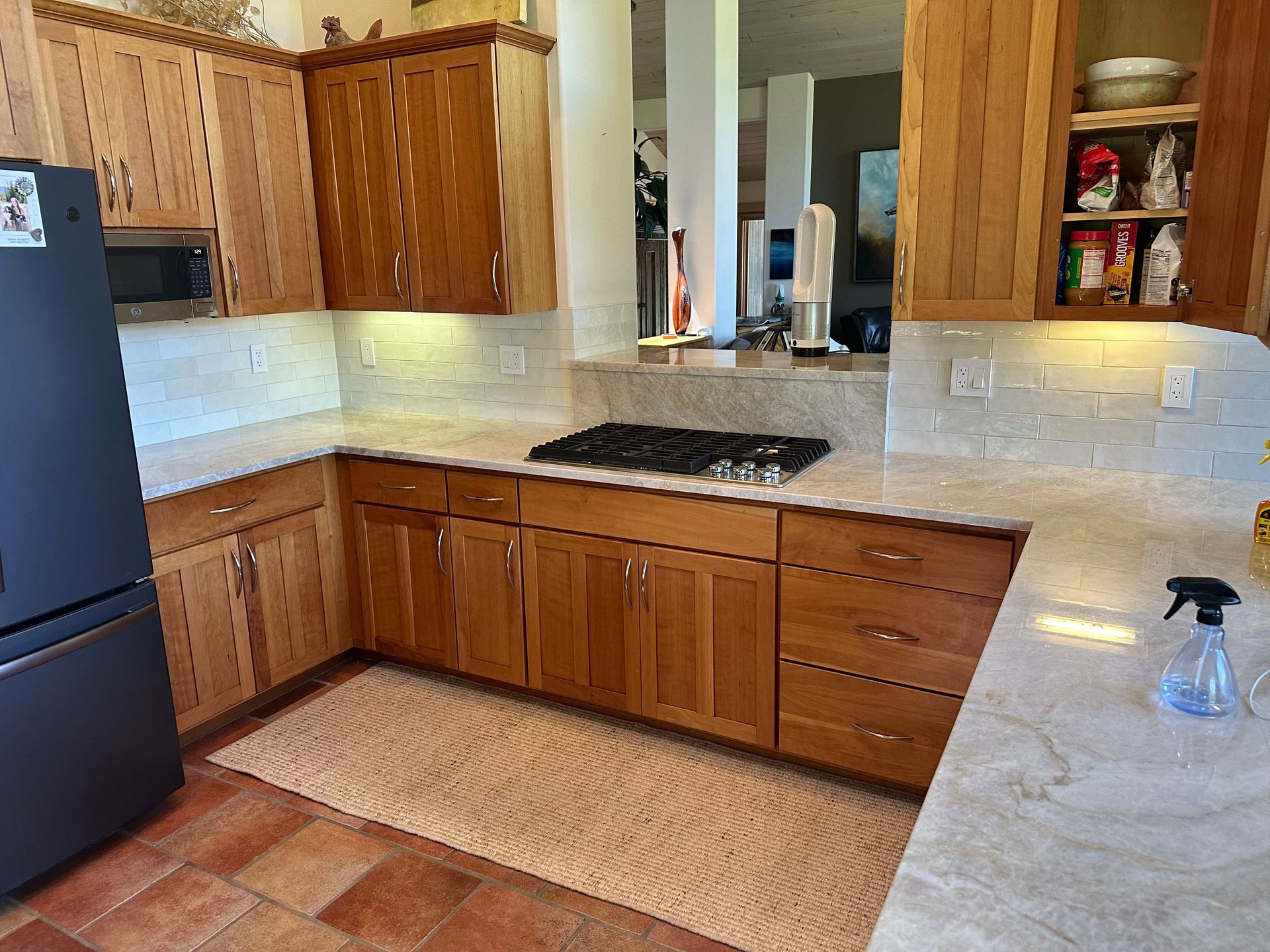 Kitchen with light wood cabinets, granite countertops, and a gas stove.