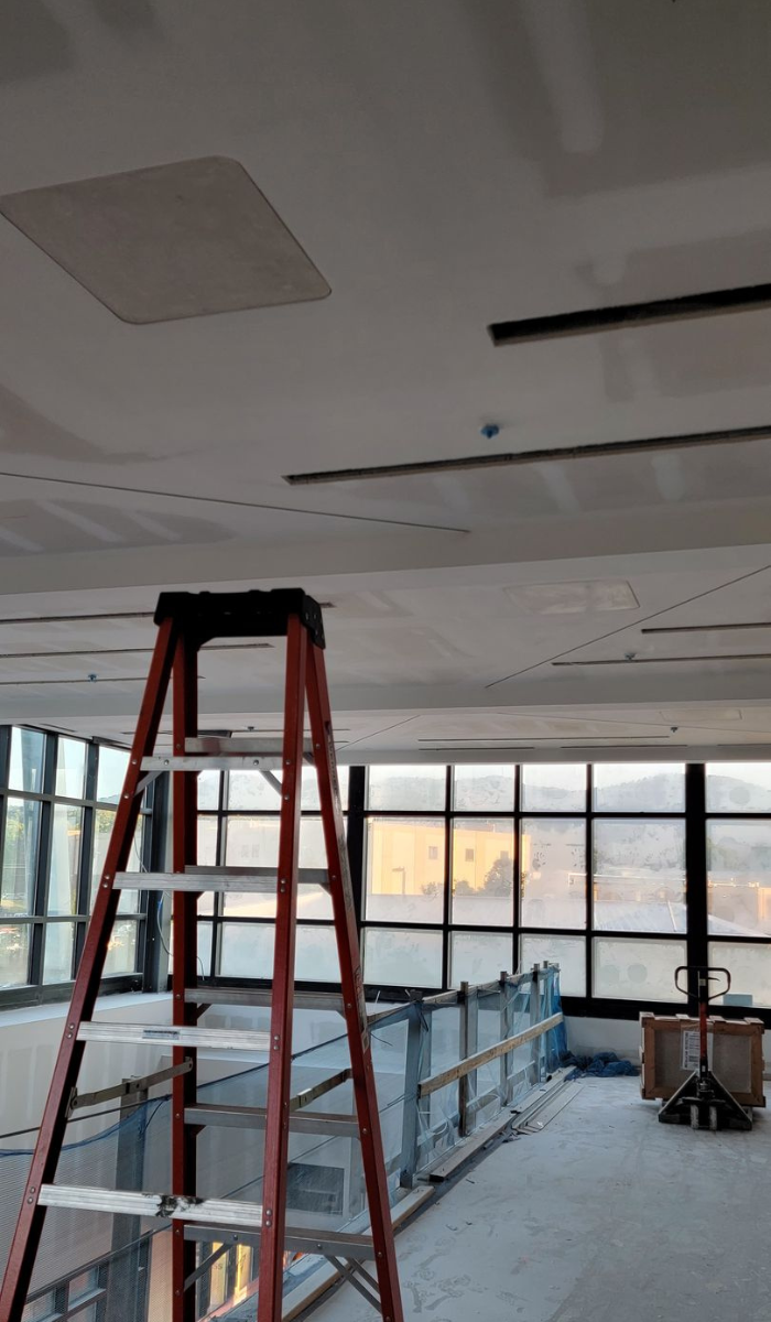 Wooden ceiling under construction with plumbing pipes visible.