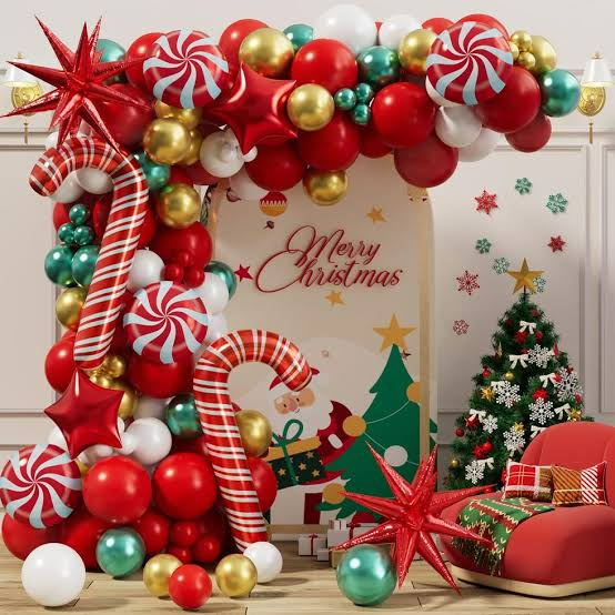 Festive Christmas decoration with red, gold and green ornaments framing a holiday card and gift box