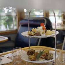 Two-tiered serving tray with assorted appetizers on a dining table in a bright lounge