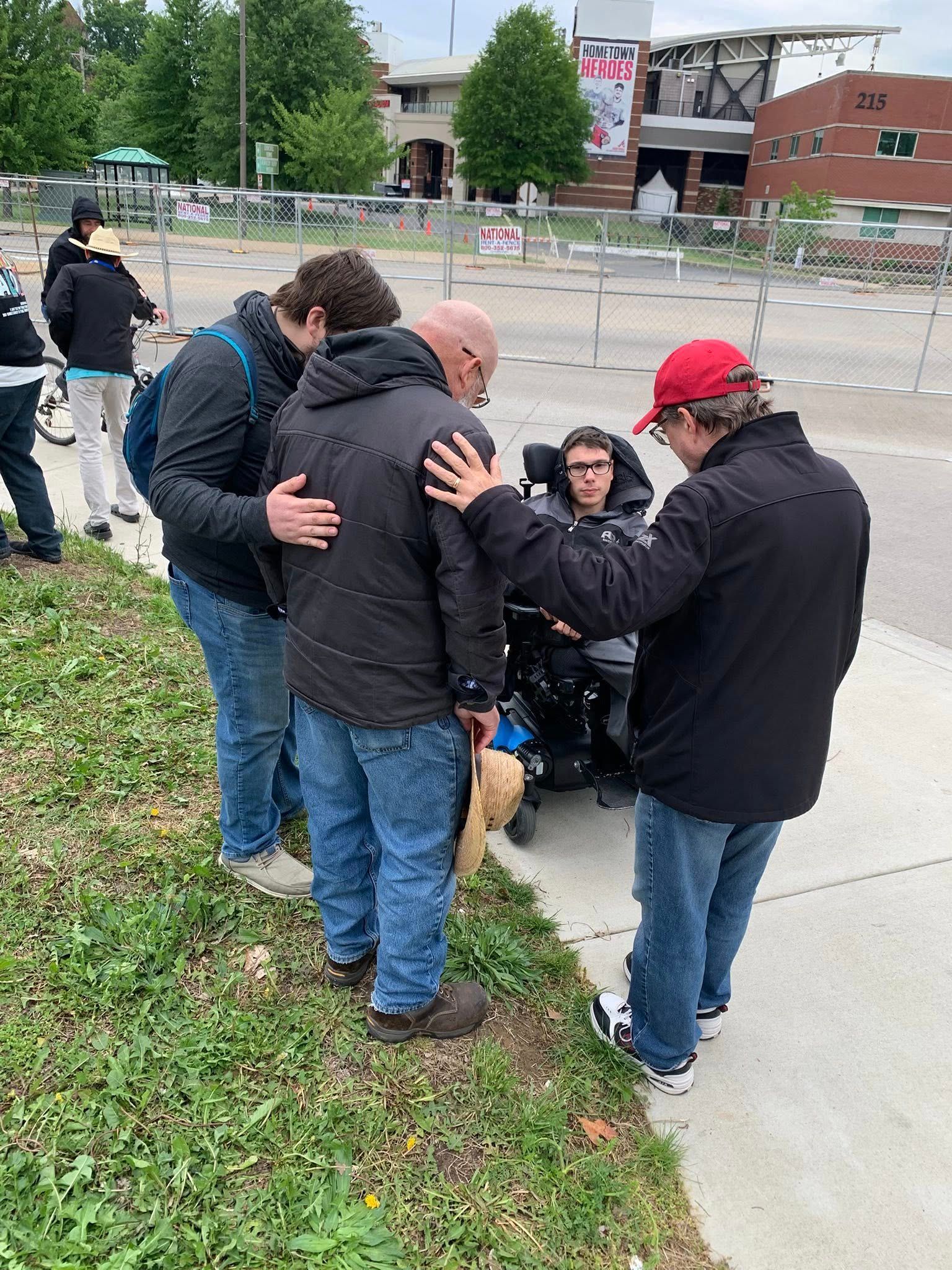 SFOI evangelists praying with a young fan outside a stadium — the moments your prayers make possible.