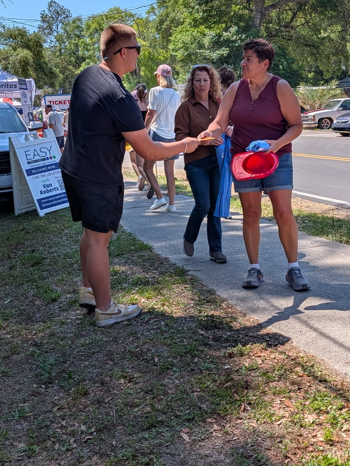An SFOI evangelist handing a Gospel tract to a fair-goer — the tract keeps working long after the conversation ends.