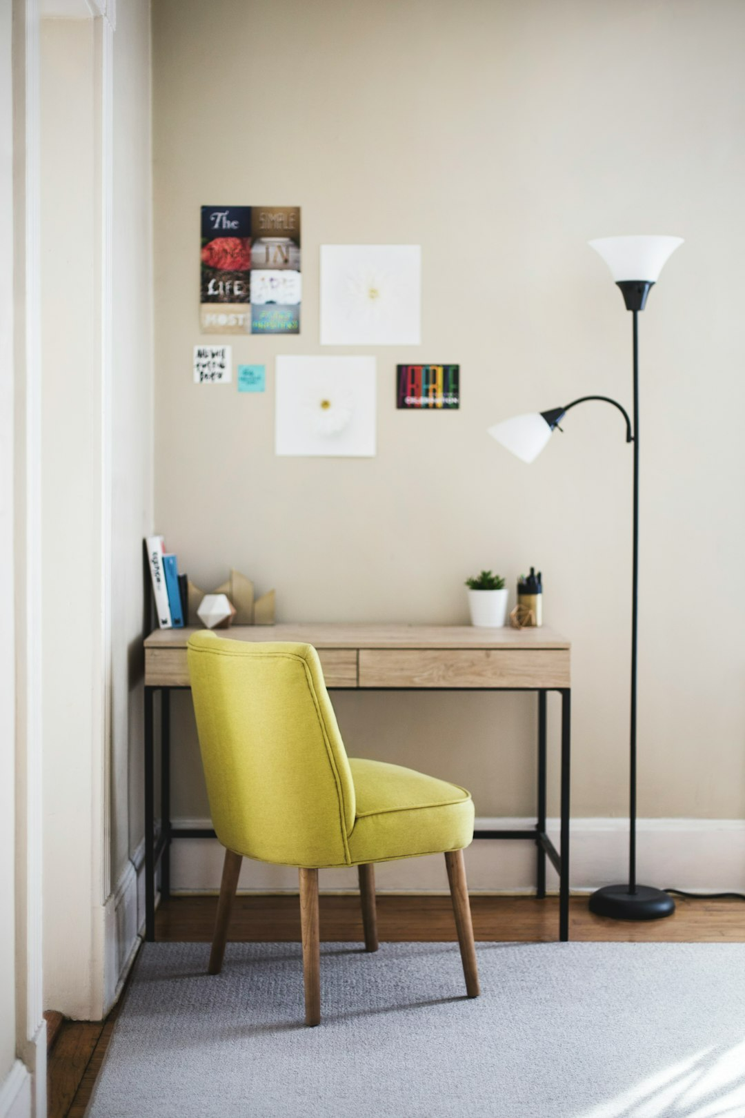 A yellow chair is sitting in front of a desk in a room.