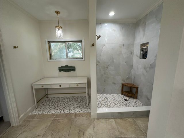 Bathroom vanity and walk-in shower with white tile, mosaic floor, and a windowed dressing area.