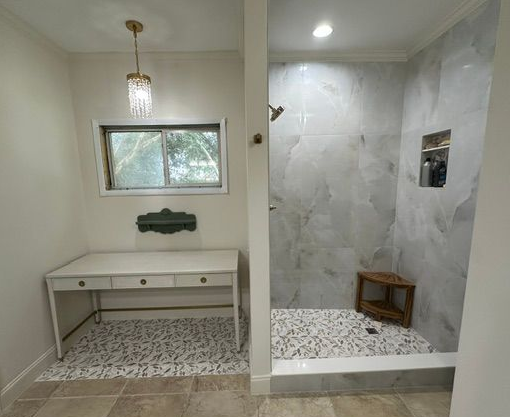 Modern bathroom with white vanity, tiled shower, mosaic floor, and small window
