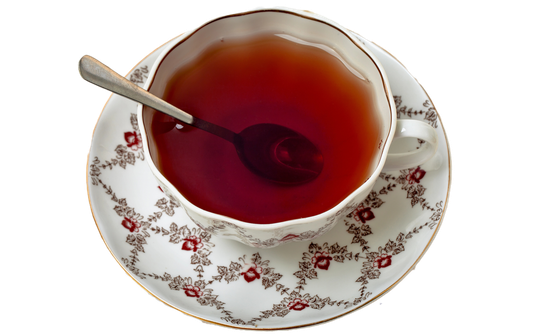 Tazza da tè con cucchiaino, su piattino con motivo floreale.