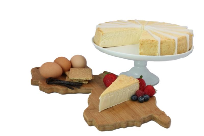A slice of cheesecake is on a wooden cutting board