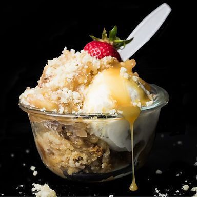 A bowl of ice cream with a spoon and a strawberry on top