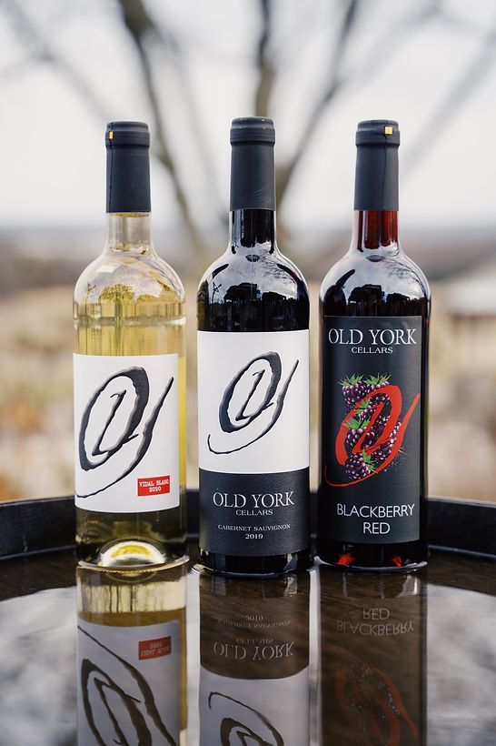 Three bottles of wine are sitting on a table.