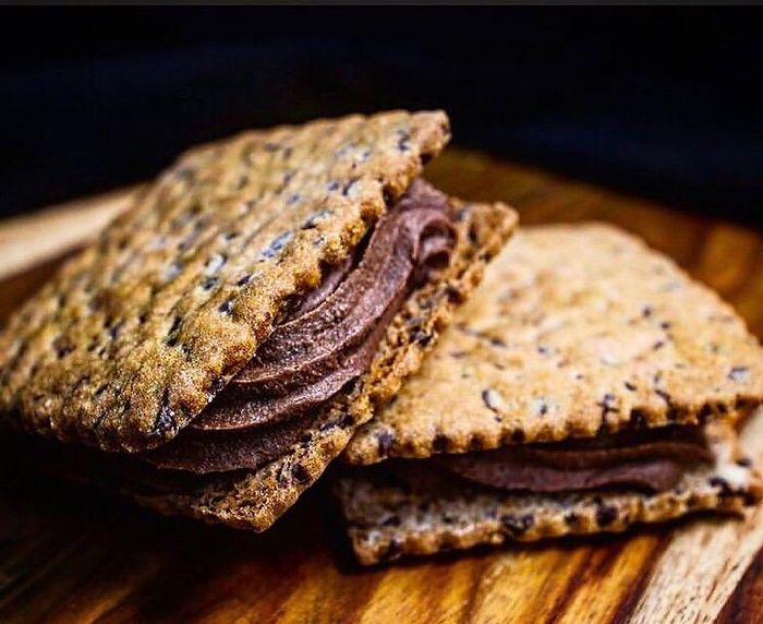 A close up of a cookie sandwich on a wooden table.