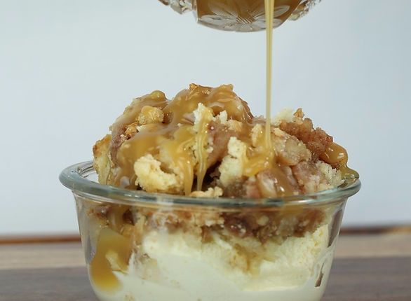 Dessert parfait: vanilla ice cream, topped with crumble and caramel sauce being drizzled from above.