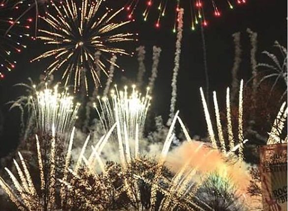 Fireworks exploding in the night sky with trails of light and colorful bursts.